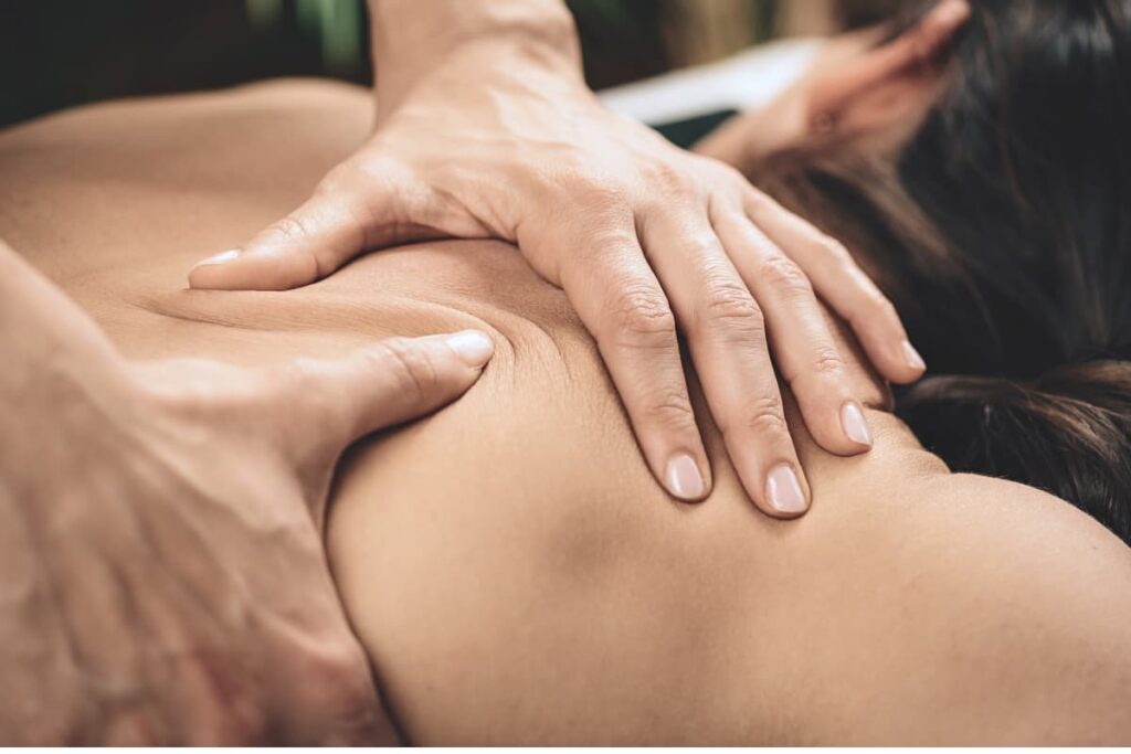 Therapist performing a massage to alleviate frozen shoulder pain.